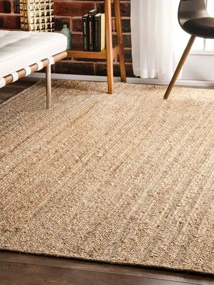 Room with a jute carpet, a wooden bench, and a bookshelf